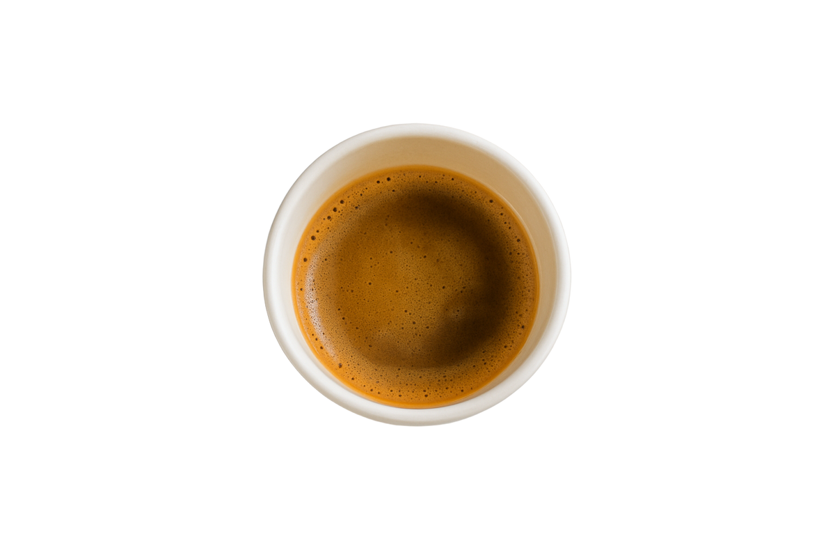 Espresso shot in a white cup on a light gray background