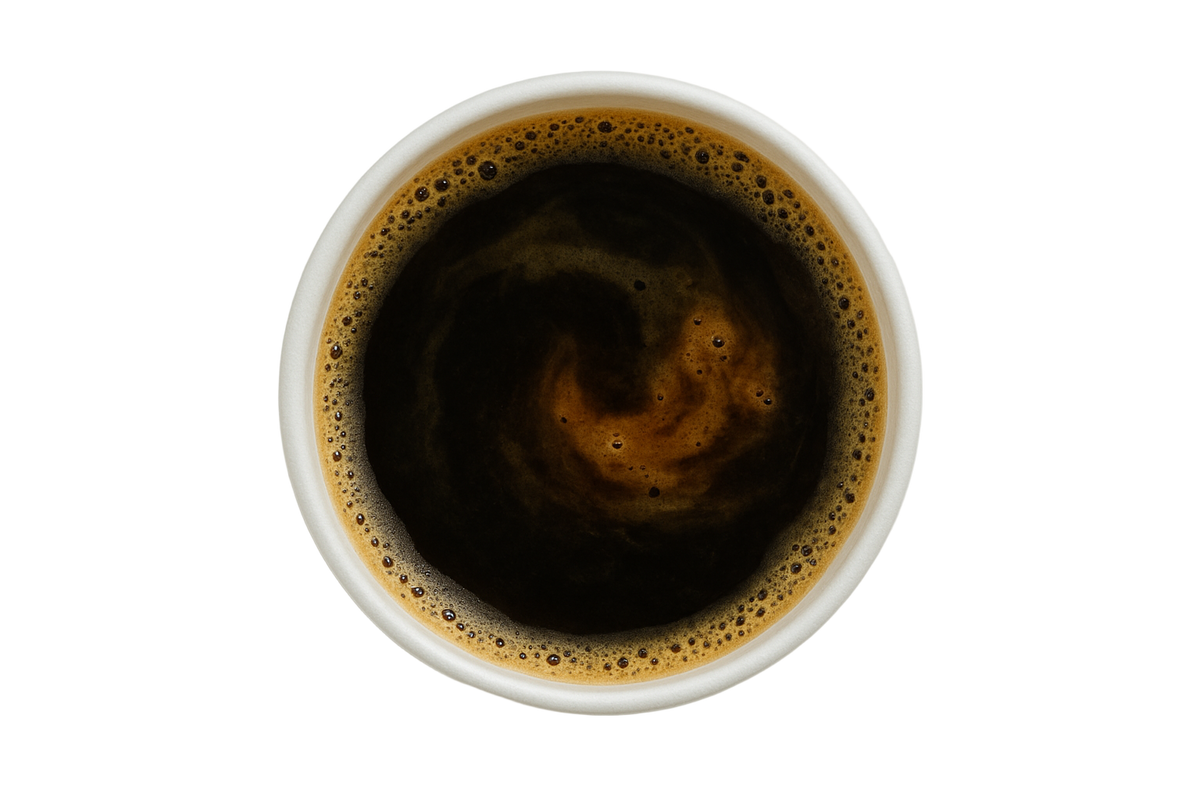 Top-down view of a cup of red eye black coffee with a white background